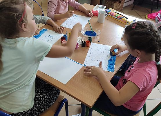 Uczennice malujące prace plastyczne.
