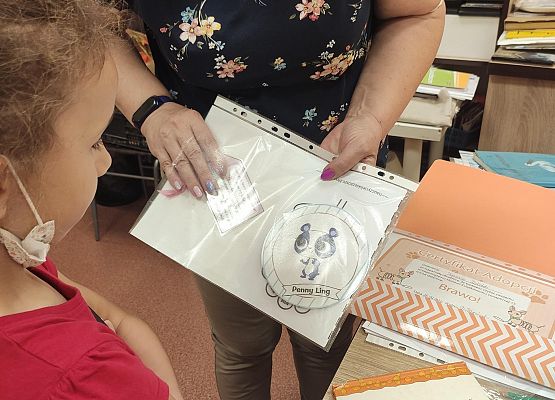 Uczennica wypożycza książkę.