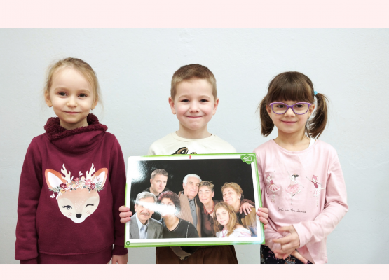 zdjęcie trzech przedszkolaków z plakatem