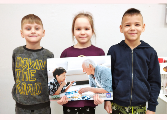 zdjęcie trzech przedszkolaków z plakatem