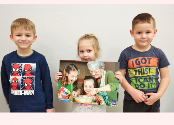 zdjęcie trzech przedszkolaków z plakatem