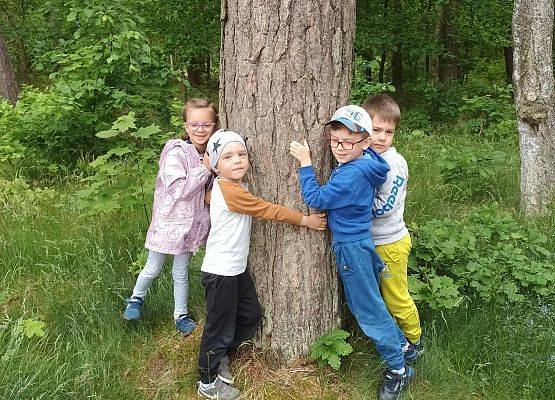 zdjęcie dzieci przytulających się do drzewa