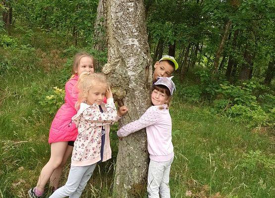 zdjęcie dzieci przytulających się do drzewa