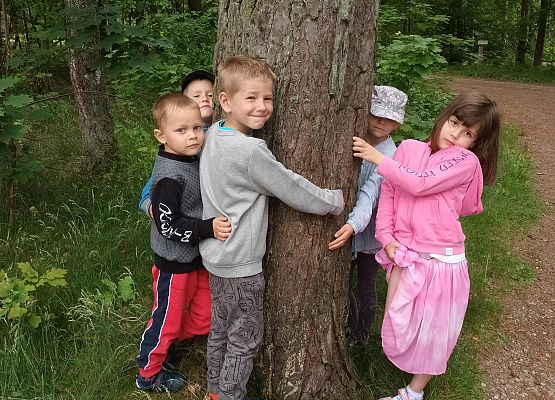 zdjęcie dzieci przytulających się do drzewa