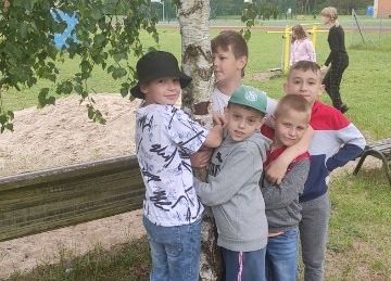 zdjęcie dzieci przytulających się do drzewa