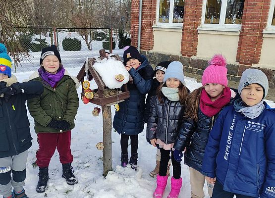 pierwszaki wieszają zrobiona karmę w karmniku