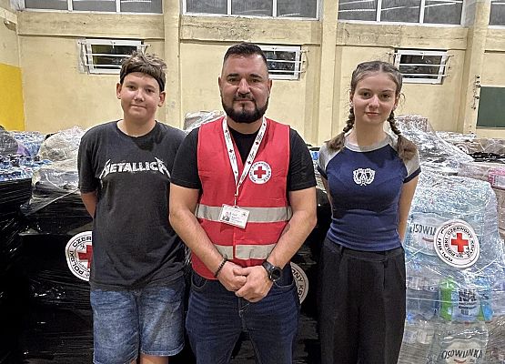 Grafika 1: Wolontariusze pomagają segregować i pakować dary dla powodzian.