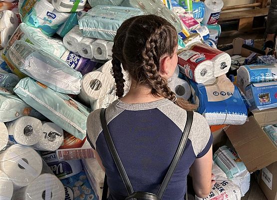 Grafika 10: Wolontariusze pomagają segregować i pakować dary dla powodzian.